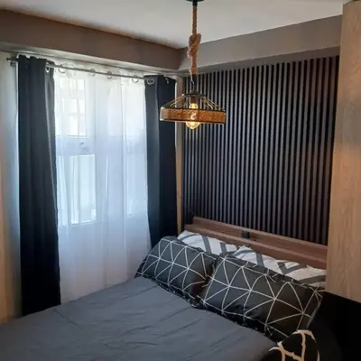 a bedroom with a bed with a window and a chandelier at Blk Pod in Punta