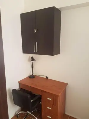 a desk with a chair and a cabinet on the wall at The Journeyman Suite at Covent Garden Sta Mesa Manila in Manila