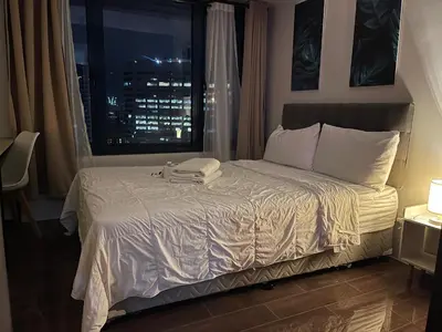 a bedroom with a bed with a view of a city at Destina Stays @Air Residences Makati, MetroManila in Manila