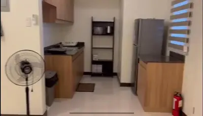 a small kitchen with a refrigerator and a fan at Casa Chena in Manila