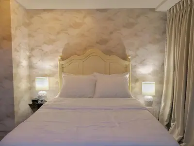 a bedroom with a white bed with two lamps at Uptown BGC Taguig - One Bedroom in Manila