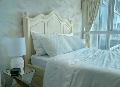 a bedroom with a white bed and a window at Uptown BGC Taguig - One Bedroom in Manila