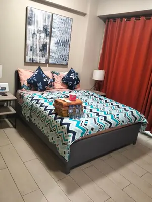 a bedroom with a bed and a red curtain at Nadzcondotel-2 Two Palmtree villas nearby NAIA Terminal 3 in Manila