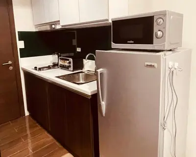 a kitchen with a microwave on top of a refrigerator at Destina Stays@ Air Residences Makati, Metro Manila in Manila