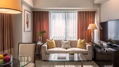 a living room with a couch and a table at Aruga Apartments by Rockwell Makati in Manila