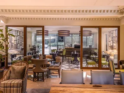 a restaurant with tables and chairs and a lobby at Aruga Apartments by Rockwell Makati in Manila