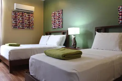 a hotel room with two beds with white sheets at Purple Tree Bed & Breakfast in Manila