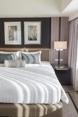 a bedroom with a large white bed and a lamp at Seda Nuvali Laguna near Tagaytay in Santa Rosa
