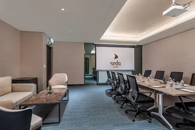 a conference room with tables and chairs and a screen at Seda Nuvali Laguna near Tagaytay in Santa Rosa
