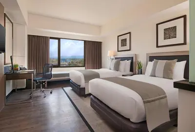 a hotel room with two beds and a desk at Seda Nuvali Laguna near Tagaytay in Santa Rosa