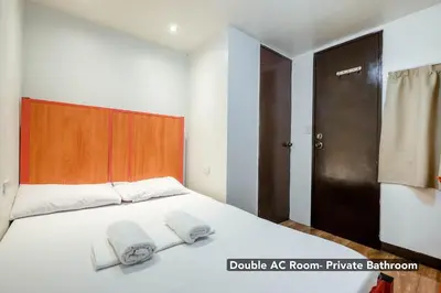 a bedroom with a bed with two towels on it at Stay Malate (Wanderers Guest House) in Manila