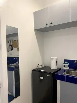 a kitchen with a black refrigerator and a sink at El Pueblo Studio - Manila in Manila