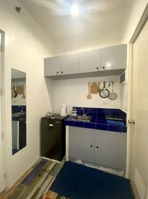 a small kitchen with blue counters and a sink at El Pueblo Studio - Manila in Manila