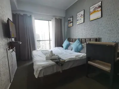 a bedroom with a bed with a teddy bear on it at warm makati in Manila