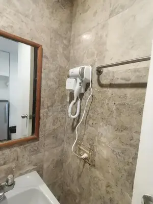 a bathroom with a hair dryer on a wall at warm makati in Manila