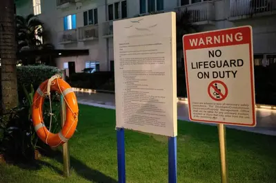 a sign in the grass with a no lifeguard on duty at Sea Residences - Classy Unit Near Mall of Asia, Arena, Ayala, Ikea, Okada, SMX, PITX, Airport in Manila