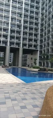 a large building with a swimming pool in front of it at Shore 2 Tower 1 JMB Staycation in Manila