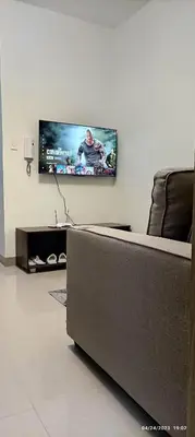 a living room with a couch and a flat screen tv at Shore 2 Tower 1 JMB Staycation in Manila