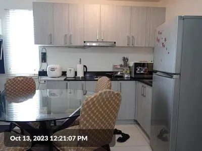 a kitchen with a glass table and a refrigerator at The SCENIC: Comfortable living by Awsom Phil in Manila