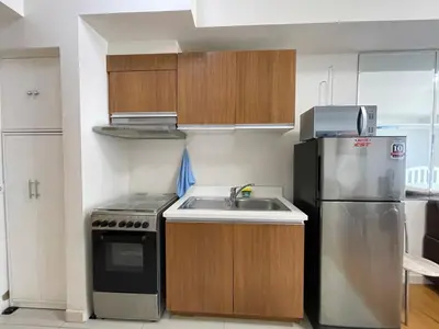 a small kitchen with a sink and a refrigerator at Condo for Short Stay in Ermita near SLMEC & US Embassy in Manila