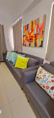 a couch with colorful pillows in a living room at Newport's STAR at Montecito Residential Resort in Manila