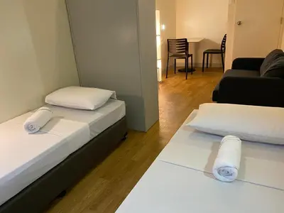 a room with two beds and a living room at Burgos Hub Hostel in Manila