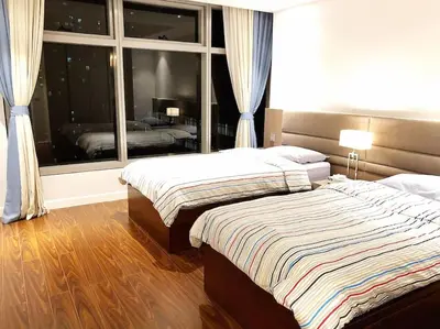 a bedroom with two beds and a large window at 3BR luxury apartment in Ortigas with swimming pool in Manila