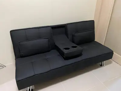 a black couch sitting in a room at Sea Residences MOA by Ruffa's Condotel in Manila