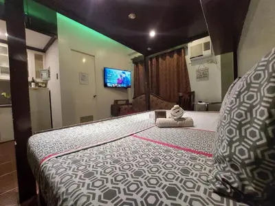 a bedroom with a large bed with a teddy bear sitting on it at Condo near NAIA Terminals Fasanvej Studio Netflix in Manila
