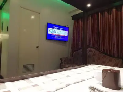 a room with a television on a wall with a table at Condo near NAIA Terminals Fasanvej Studio Netflix in Manila