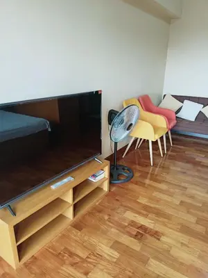 a living room with a large television and a couch at 20h staycation away from home in Manila