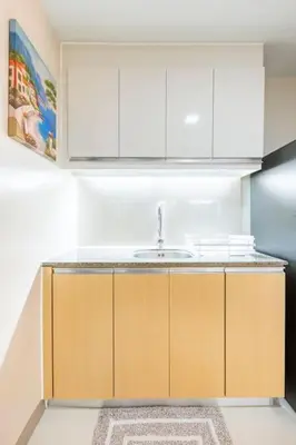 a kitchen with white cabinets and a sink at Luxury living @ Eastwood in Manila