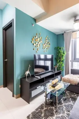 a living room with a television and a blue wall at Luxury living @ Eastwood in Manila