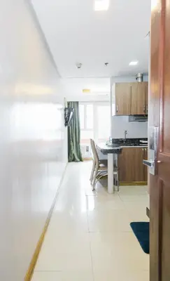 a kitchen with a table and a dining room at Pacific Bay Grand Suites in Manila