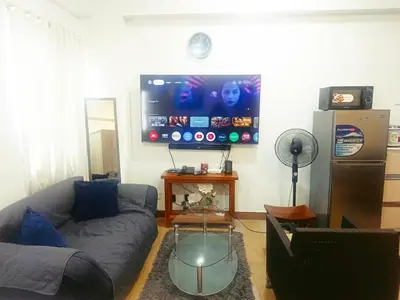 a living room with a couch and a flat screen tv at Happy Stays A - 300mbps - 65