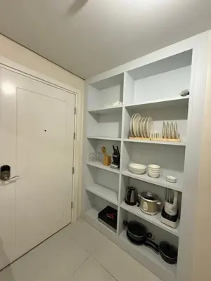 a kitchen with white shelves and a door at Studio penthouse 1 in Manila