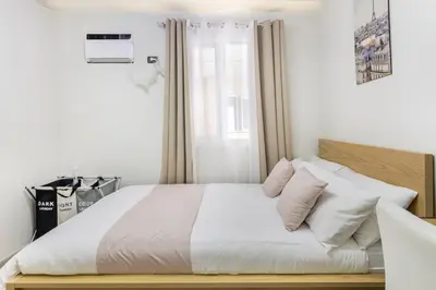 a bedroom with a bed with white sheets and pillows at Modern Comfort Your Gateway to Quezon City One Free Parking in Manila