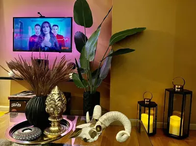 a living room with a table with a tv on the wall at The Milano Residences by Versace Stylish 1BR Condo in Manila