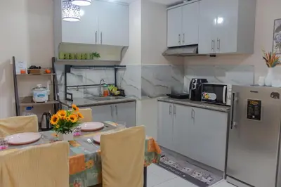 a kitchen with a table with chairs and a refrigerator at Spacious 3BR Condo at Little Baguio Terraces San Juan City in Manila