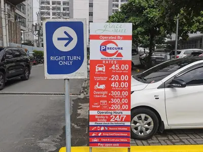 a sign for a right turn only sign next to a car at Sunshine at Grace nr BGC in Manila