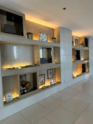 a living room with a wall of shelves at 331D Near MOA and Airport Pool View Fast WiFi Balcony in Manila
