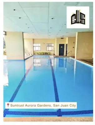 a large swimming pool with blue water in a building at Lovely Modern 2BR Condo in Aurora Gardens San Juan City in Manila
