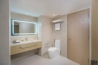 a bathroom with a toilet and a sink and a mirror at Seda Manila Bay near Ayala Malls in Manila