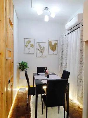 a dining room with a black table and chairs at L and D Homestay in Manila