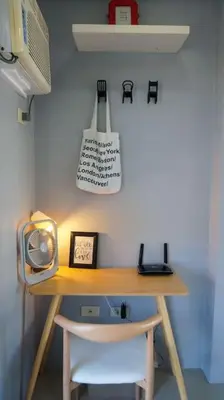 a desk with a chair and a clock on a wall at THE FIKA ROOM near MNL Airport - Scandi Studio Unit with Fast Wi-Fi & Netflix - Read Full Property Desc before booking in Manila