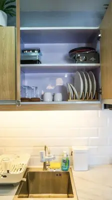 a kitchen with a sink and plates on a shelf at THE FIKA ROOM near MNL Airport - Scandi Studio Unit with Fast Wi-Fi & Netflix - Read Full Property Desc before booking in Manila