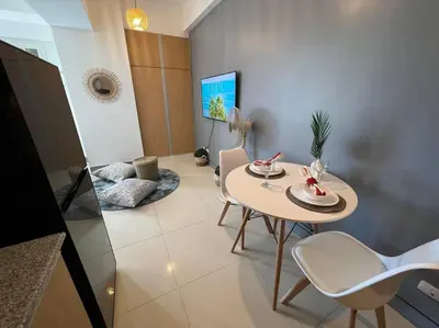 a dining room with a table and chairs in a room at Chic and Cozy Studio Viceroy Residences Taguig in Manila