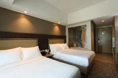 a hotel room with two beds and a bathroom at Sotogrande Hotel Katipunan in Manila