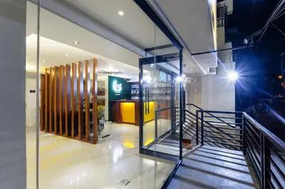 a lobby with a staircase and a glass wall at Nest Nano Suites Poblacion - Makati in Manila
