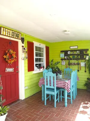 a porch with a table and chairs and a red door at Madie's Place Guest House in Santa Rosa